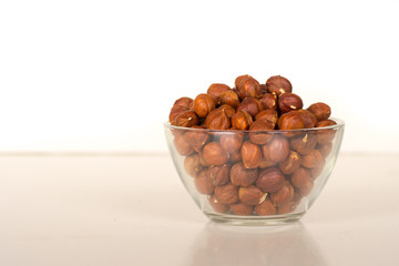Fototapeta na wymiar hazelnut kernels in transparent glass bowl