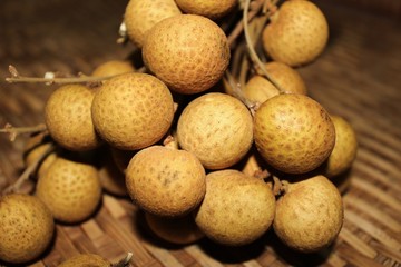 Longan fruits or Dimocarpus longan or Dragon eye fruit on the wooden wicker.