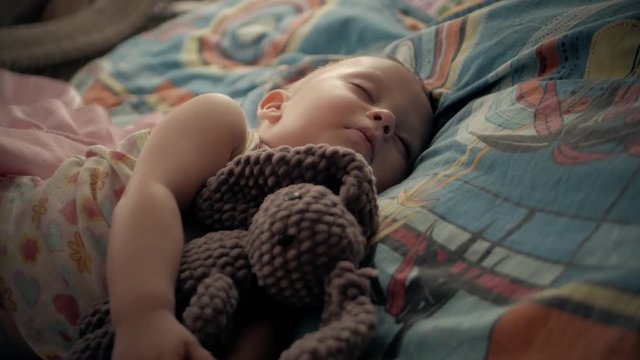 Sweet baby boy sleeping with teddy bear.