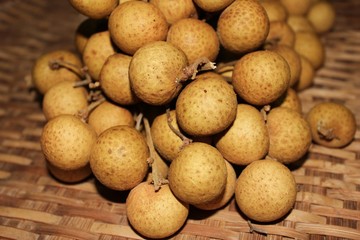 Longan fruits or Dimocarpus longan or Dragon eye fruit on the wooden wicker.