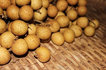 Longan fruits or Dimocarpus longan or Dragon eye fruit on the wooden wicker.