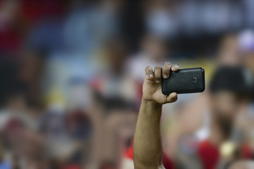 Mobile in the hand of spectators.