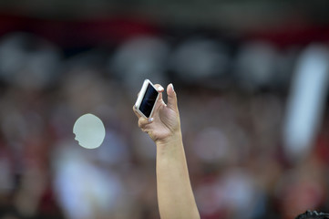 Mobile in the hand of spectators.