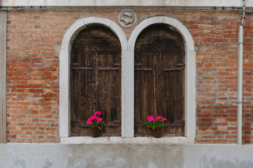 Fototapeta na wymiar Architectural background of two old arch windows with flowerpots