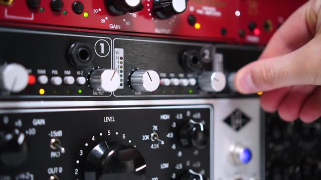 Recording studio gear and effects pushed by an engineers hand.