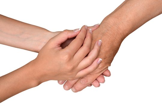 Young Woman's Hands Touching and Holding an Old Woman's Hand