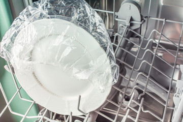 White plate in the shower cap in the dishwasher