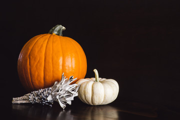 Orange and White Pumpkins with Smudge Bundle on Brown Table