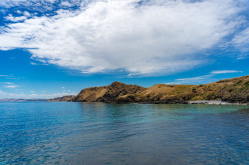 Obraz premium Ocean coastline with picturesque hills and deep blue water