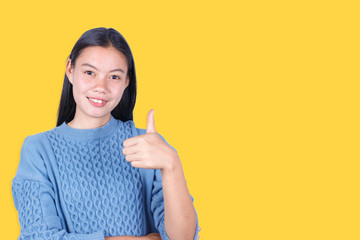 Portrait of Young woman show thumb up isolated on yellow background