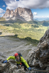 young attractive female mountain climber in the Dolomites of italy with a great view of the...