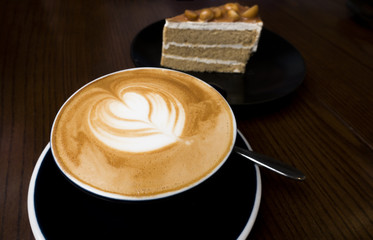 Coffee latte with cakes on the dark wood table.