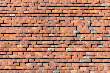 Fototapeta premium Background from a house wall made of red old shingles