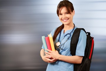 Attractive young female doctor student on background