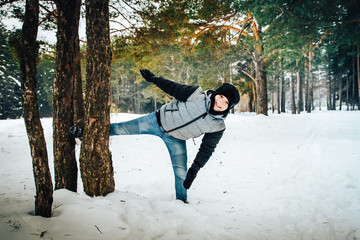 Teenager boy having fun in winter forest