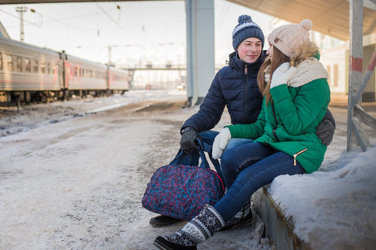 Couple at railway station near train in a winter time