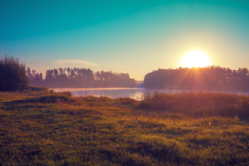 Early in the morning, sunrise over the lake. Rural landscape. Beautiful nature