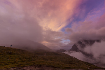 Dramatic sunset with rain clouds and rocky peaks in the Dolomite Alps, Italy, in summer