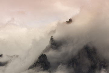 Obraz premium Dramatic sunset with rain clouds and rocky peaks in the Dolomite Alps, Italy, in summer