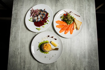 assorted fish dishes of mackerel, salmon, and trout