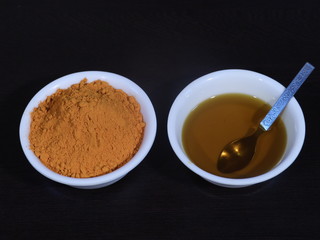Turmeric And Mustard Oil on Wooden Background,Mustard Oil and Turmeric in White Bowl on Wooden Background, Haldi and Sarso ka tel, Haldi and sarso ka tel in White Bowl on Wooden Background,