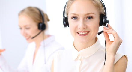 Bright  call center office. Two blonde women in a headset