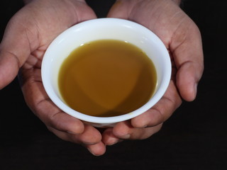 Mustard Oil in White Bowl on Wooden Background,Mustard Oil in White Bowl on Hand, Closeup of Mustard oil in Hand,