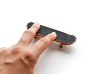 Fingerboard. A small skateboard and a hand. Close up. Isolated on white background © Dima Plotnikov