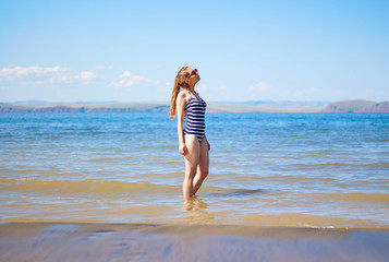 Fototapeta na wymiar Beautiful girl with glasses and swimsuit on the sea