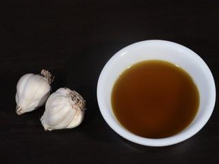 Garlic and Mustard Oil on Wooden Background, Mustard Oil on Wooden Background, Raw garlic on Wooden Background,Garlic and Mustard oil Used for All Type Body Pain,