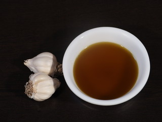 Garlic and Mustard Oil on Wooden Background, Mustard Oil on Wooden Background, Raw garlic on Wooden Background,Garlic and Mustard oil Used for All Type Body Pain,