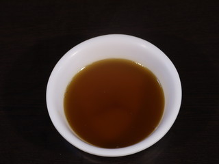 Mustard Oil in White Bowl on Wooden Background,Mustard Oil in White Bowl on Hand, Closeup of Mustard oil in Hand,