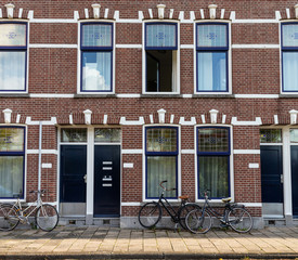 Fototapeta na wymiar Bikes in front of red brick house in Rotterdam, background