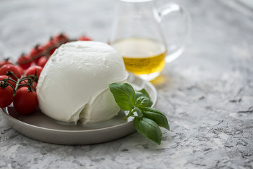 Büffelmozzarella Kugel mit Zutaten wie Tomaten, Basilikum und Olivenöl