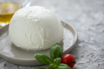 Büffelmozzarella Kugel mit Zutaten wie Tomaten, Basilikum und Olivenöl