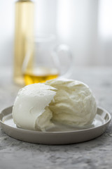 Büffel Mozzarella Kugel mit Olivenöl und weißen Balsamico auf Teller