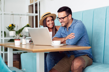 Young couple using laptop in a cafe