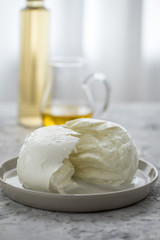 Büffel Mozzarella Kugel mit Olivenöl und weißen Balsamico auf Teller