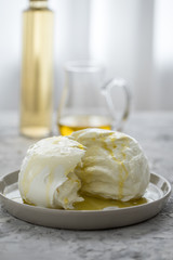 Büffel Mozzarella Kugel mit Olivenöl und weißen Balsamico auf Teller