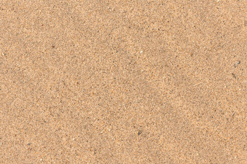 Fototapeta na wymiar Sand background with undulating structure close-up