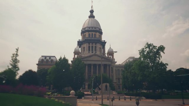 Time lapse / hyper lapse footage of the Illinois State Capitol building. Clouds roll by in the background and busy downtown traffic speeds by in a beautiful blur.