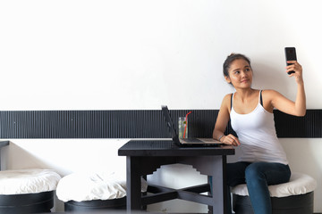 Beautiful Woman Sitting And Taking Selfie Picture With Mobile Phone