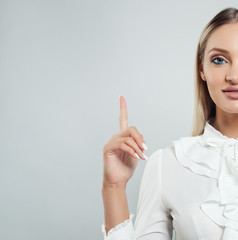 Business woman pointing her finger up on white background with copy space