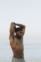 Fit man stretching at the beach