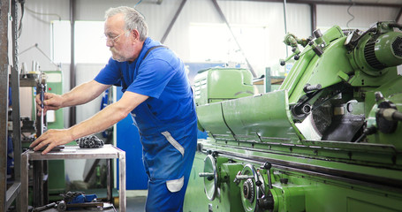 Industrial metal worker working on metal components in factory