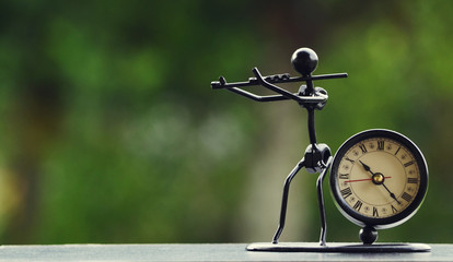 Retro clock with a unique violin statue from nuts and bolts with bokeh background