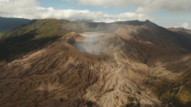 Crater with active volcano smoke in East Jawa, Indonesia. Aerial view of volcano crater Mount Gunung Bromo is an active volcano,Tengger Semeru National Park. 4K video. Aerial footage.