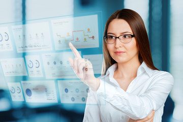 portrait of businesswoman pointing at floating screen