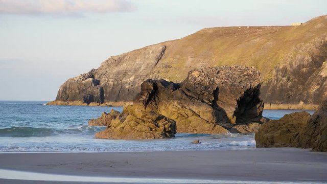 Sunset light hitting the peninsula and rocks along sango bay in Durness, Scotland, Slow motion waves hitting the shore line