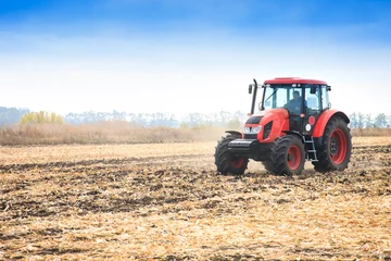 Foto op Plexiglas Moderne rode tractor die op het veld werkt © murika